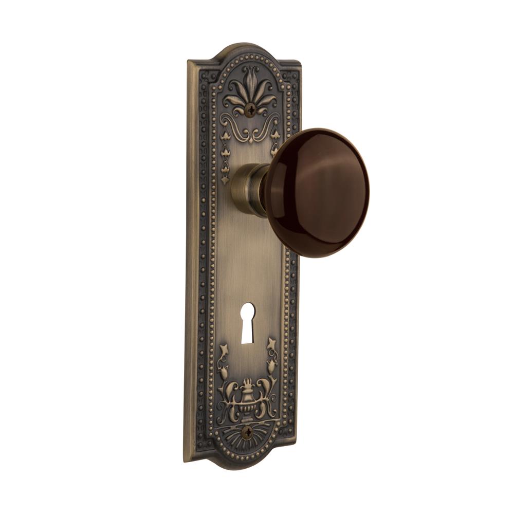 Nostalgic Warehouse MEABRN Passage Knob Meadows Plate with Brown Porcelain Knob with Keyhole in Antique Brass